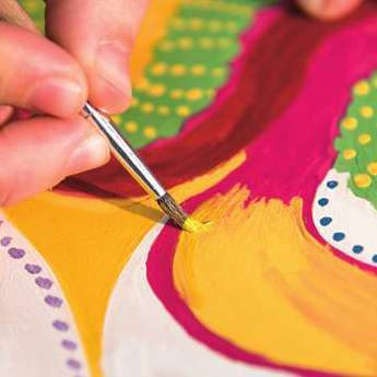 A brush applying color to an art project